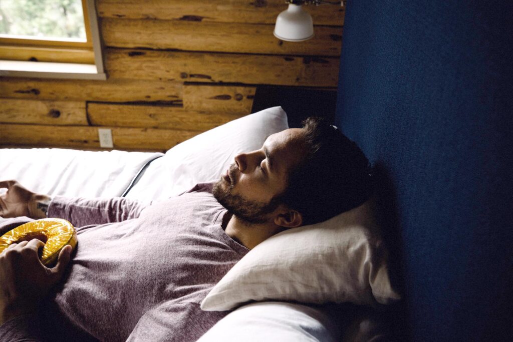 Person relaxing while holding an AmpCoil electromagnetic coil during a wellness session.